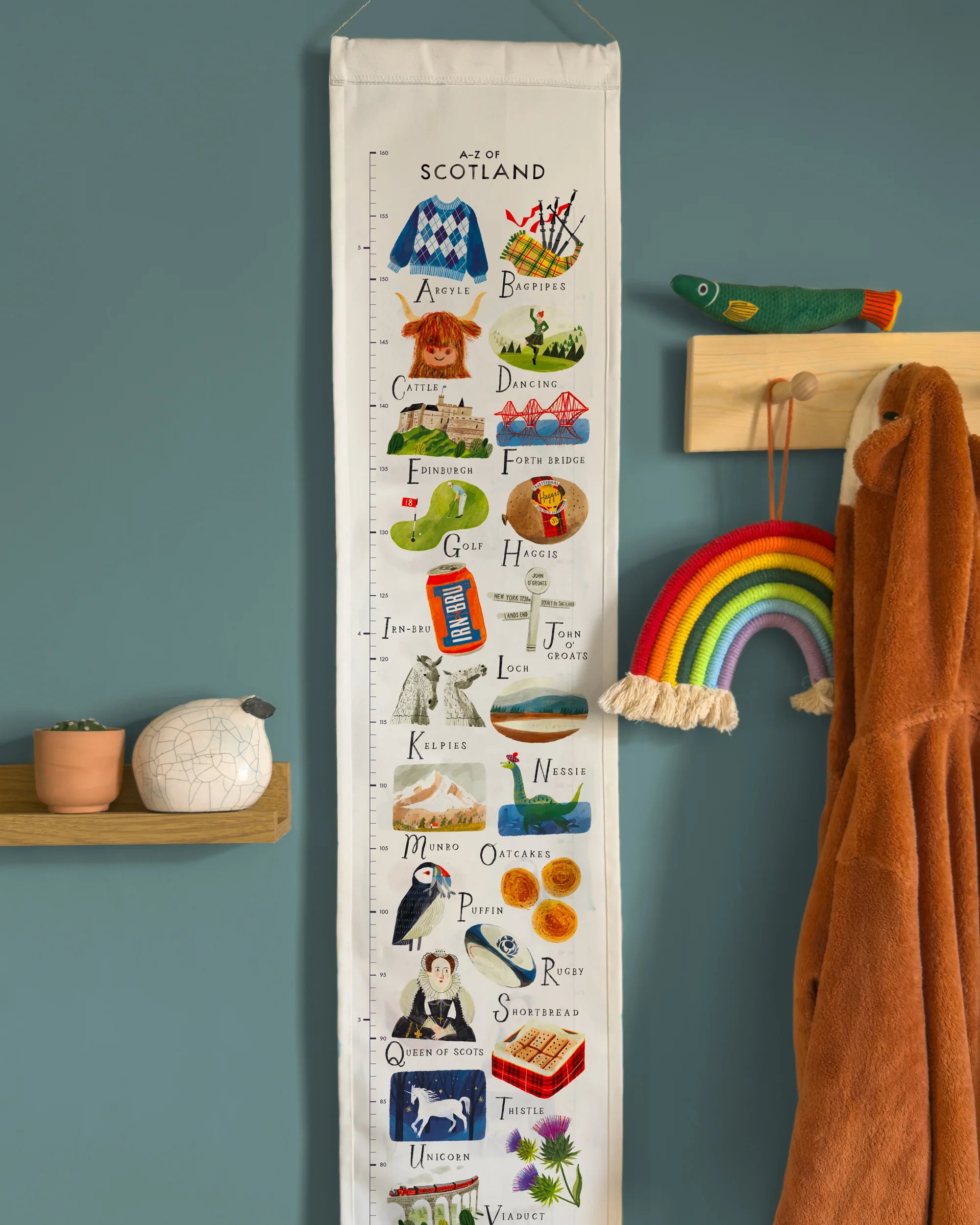 Growth chart with Scottish icons on a wall next to a rainbow decoration and coat rack.