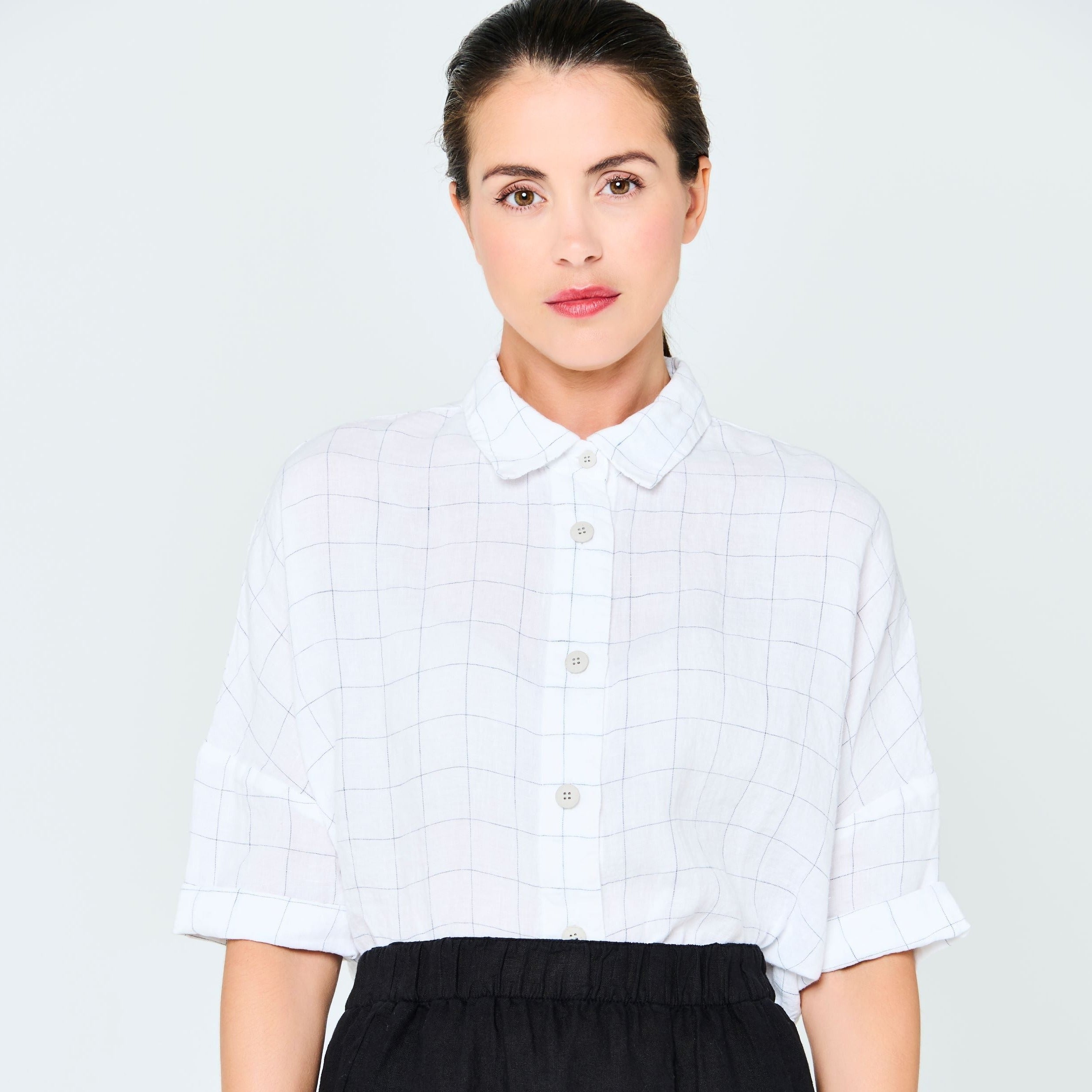 White short-sleeved collared shirt with a fine grid pattern.