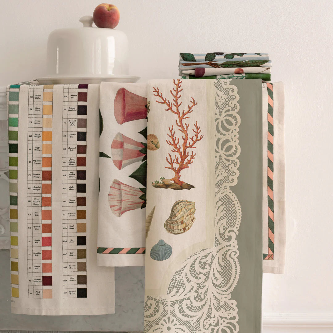 Collection of decorative towels with various patterns on a white surface.