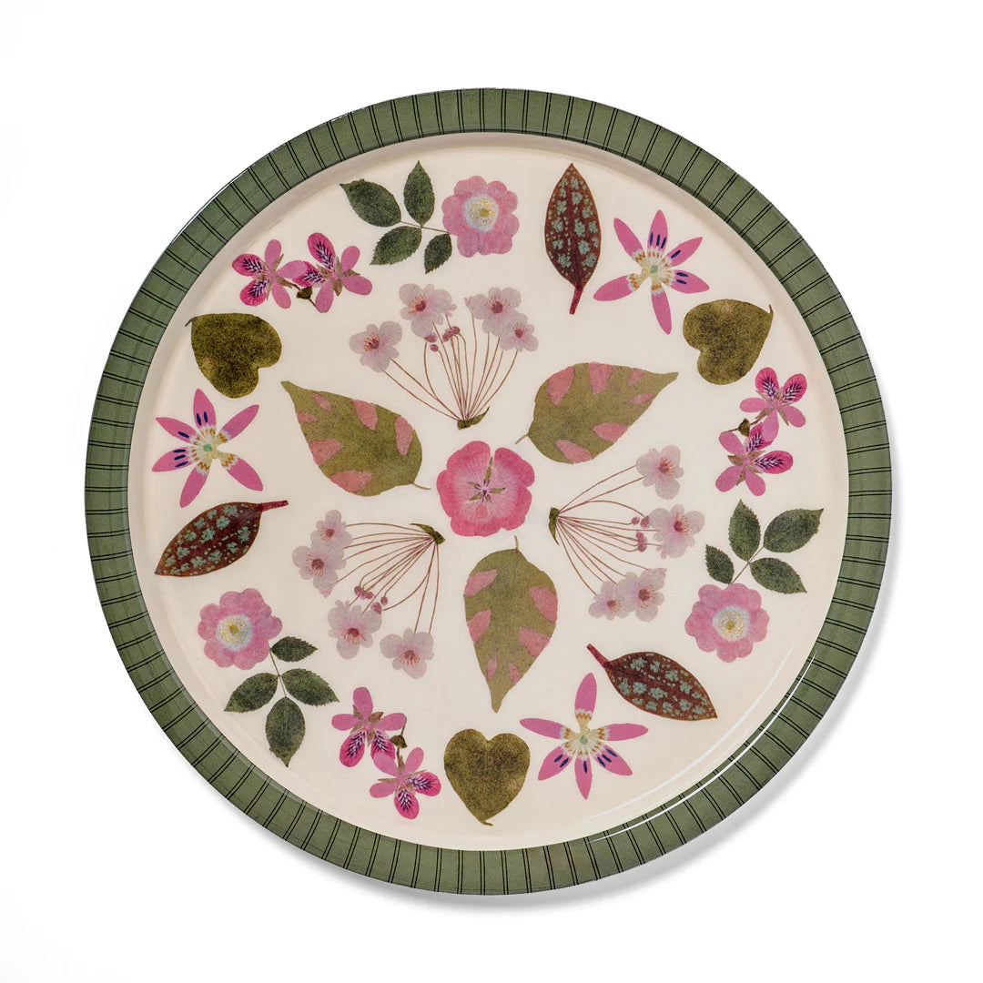 Round ceramic plate with floral and leaf pattern on a white background