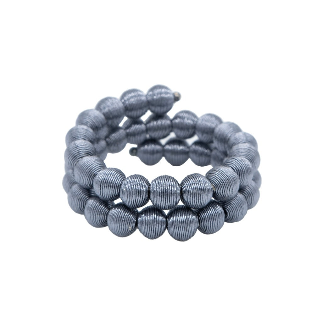 Gray beaded bracelet coiled into a spiral.  The beads are cylindrical with a ribbed texture.