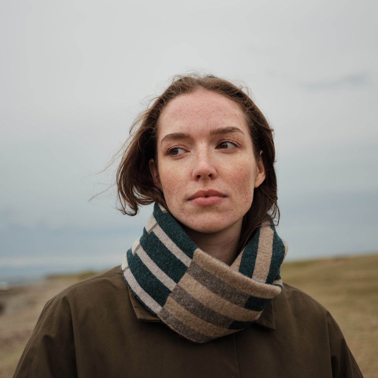 Woman wearing a checkered scarf in a natural setting