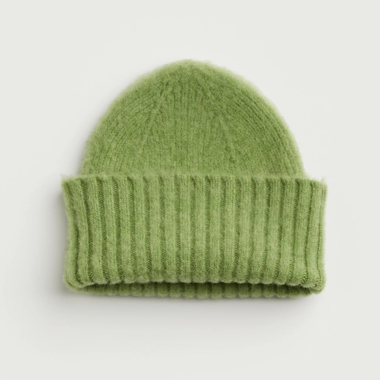 Green knit beanie on a light gray background