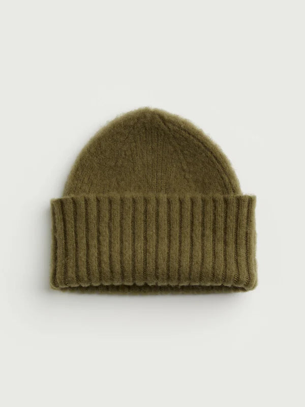 Green beanie hat on a light gray background