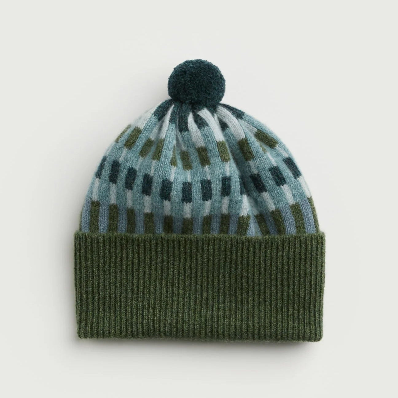 Knitted beanie with a patterned top and solid base on a light gray background