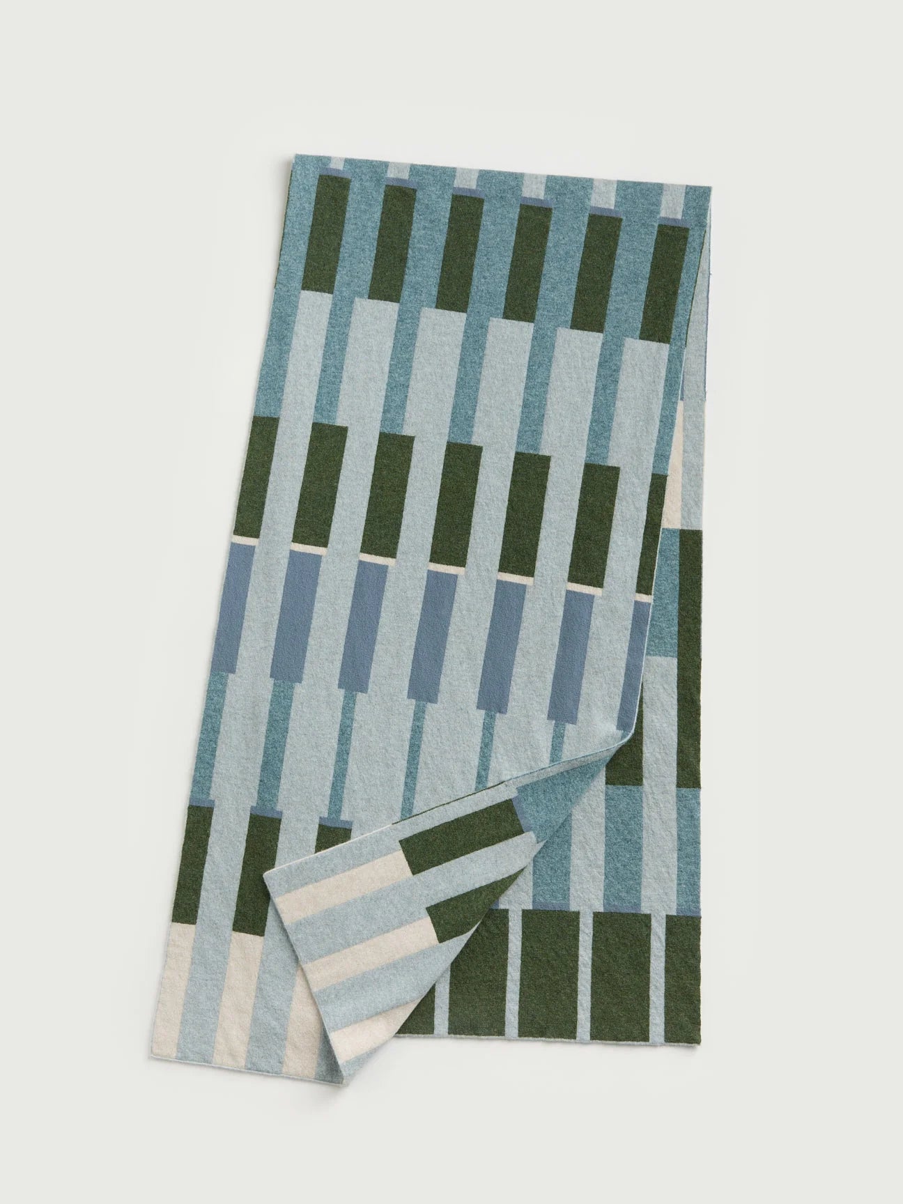Folded fabric with geometric pattern on a light gray background