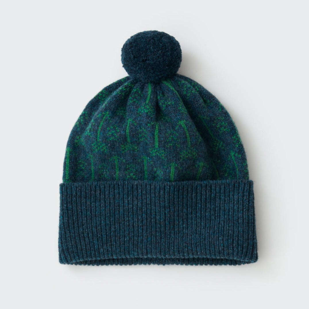 Dark teal knit beanie with a green patterned crown and matching pompom.