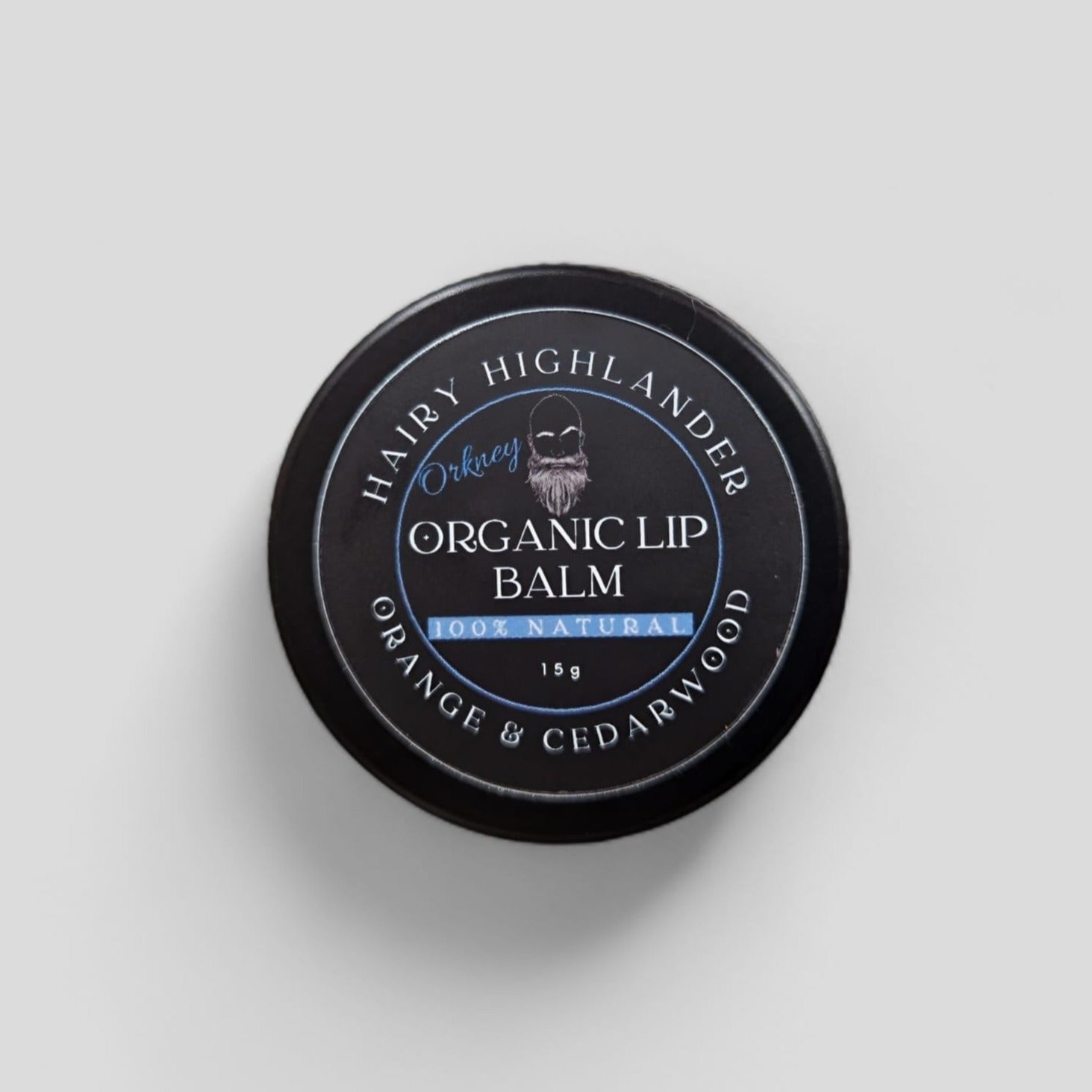 Black tin of Hairy Highlander Orkney Organic Lip Balm, 15g, orange & cedarwood, 100% natural.