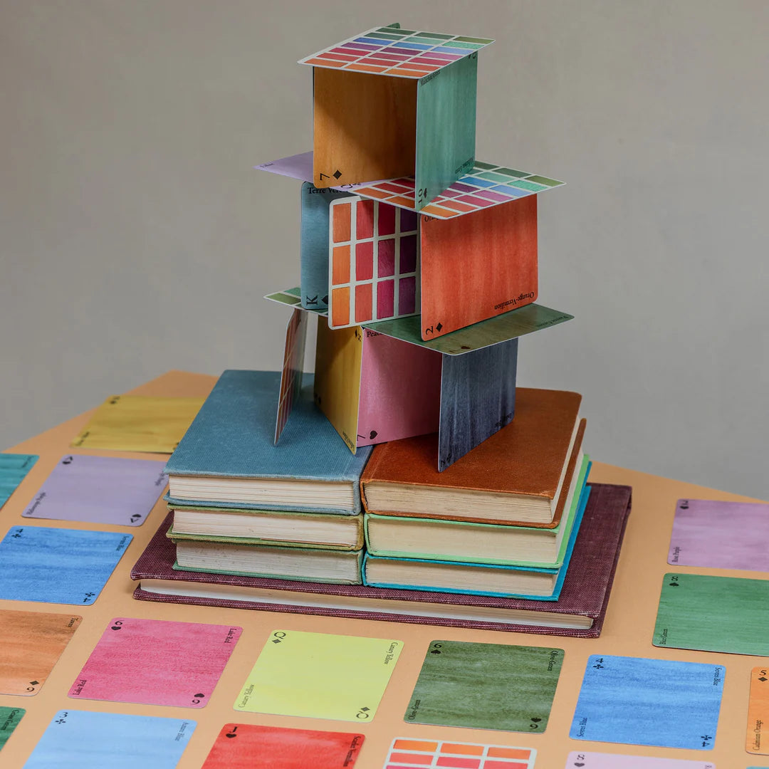 Colorful geometric bookshelf made from books on a table with color swatches.
