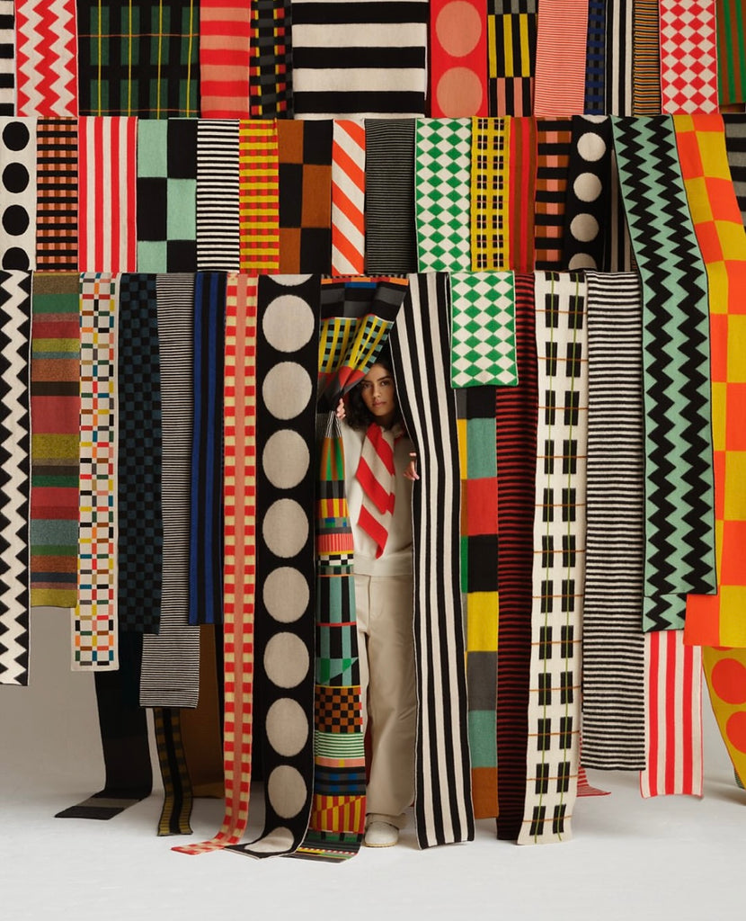 Collection of colorful woven scarves with geometric and abstract patterns in various color combinations, including black,