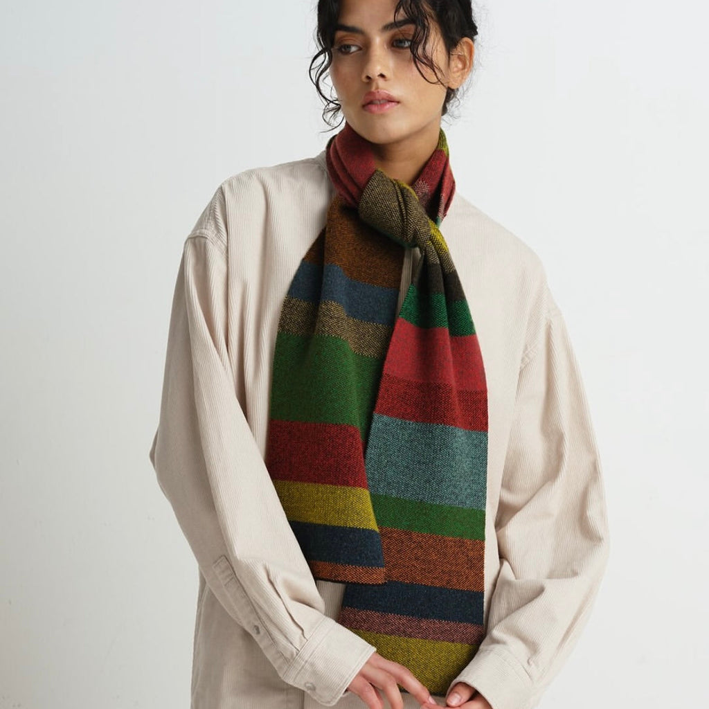 Multicolored striped wool scarf, featuring red, green, blue, and gold tones.