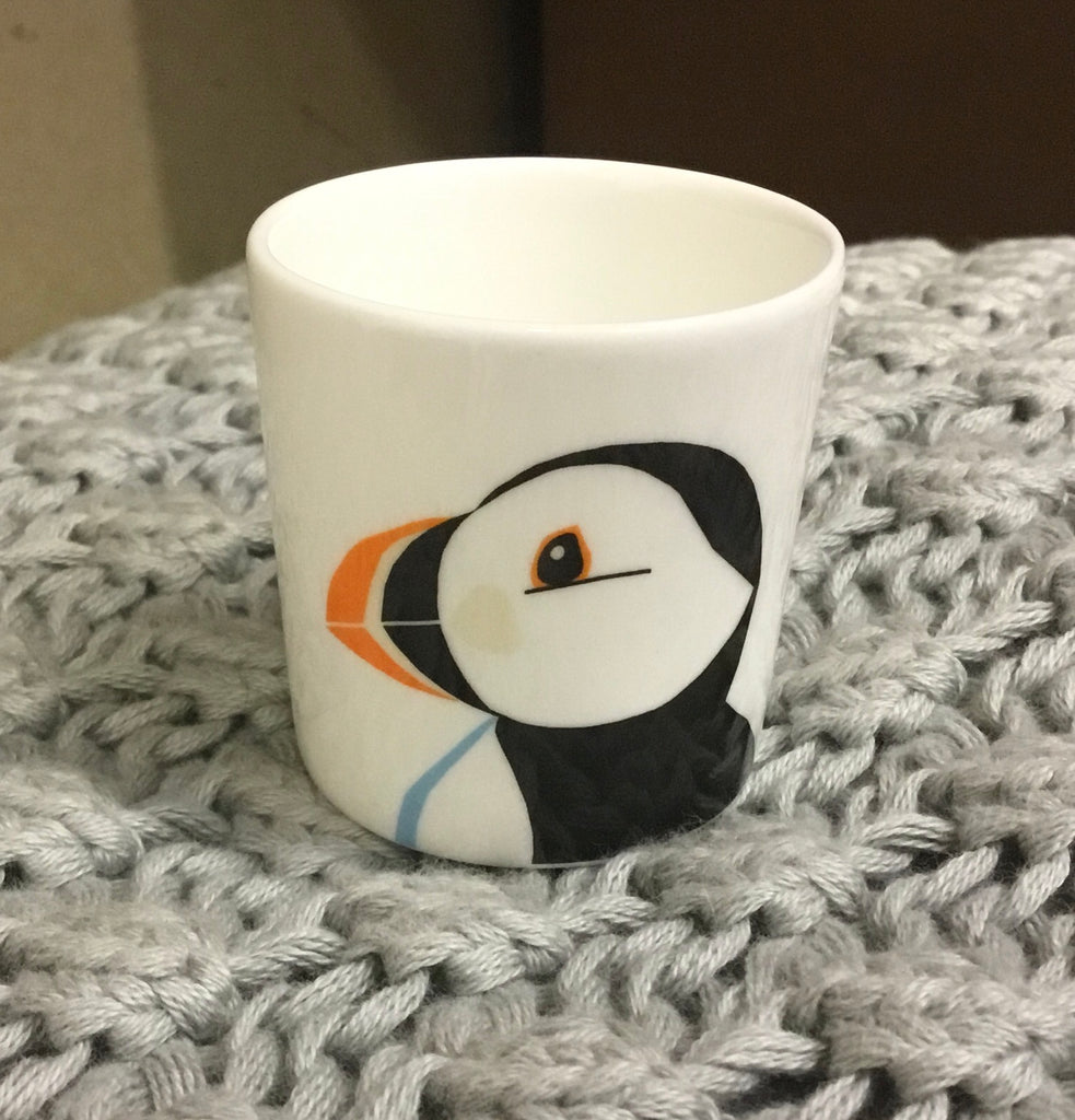 Small white mug featuring a stylized puffin illustration.