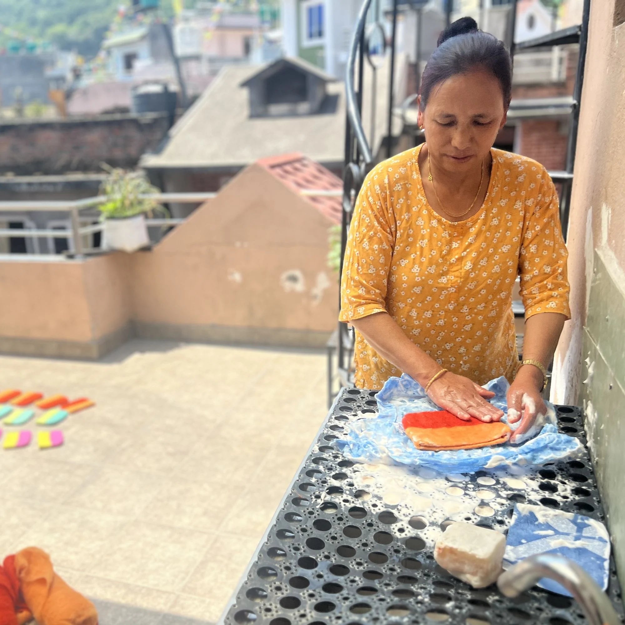 Woman preparing food on a rooftop with buildings in the background