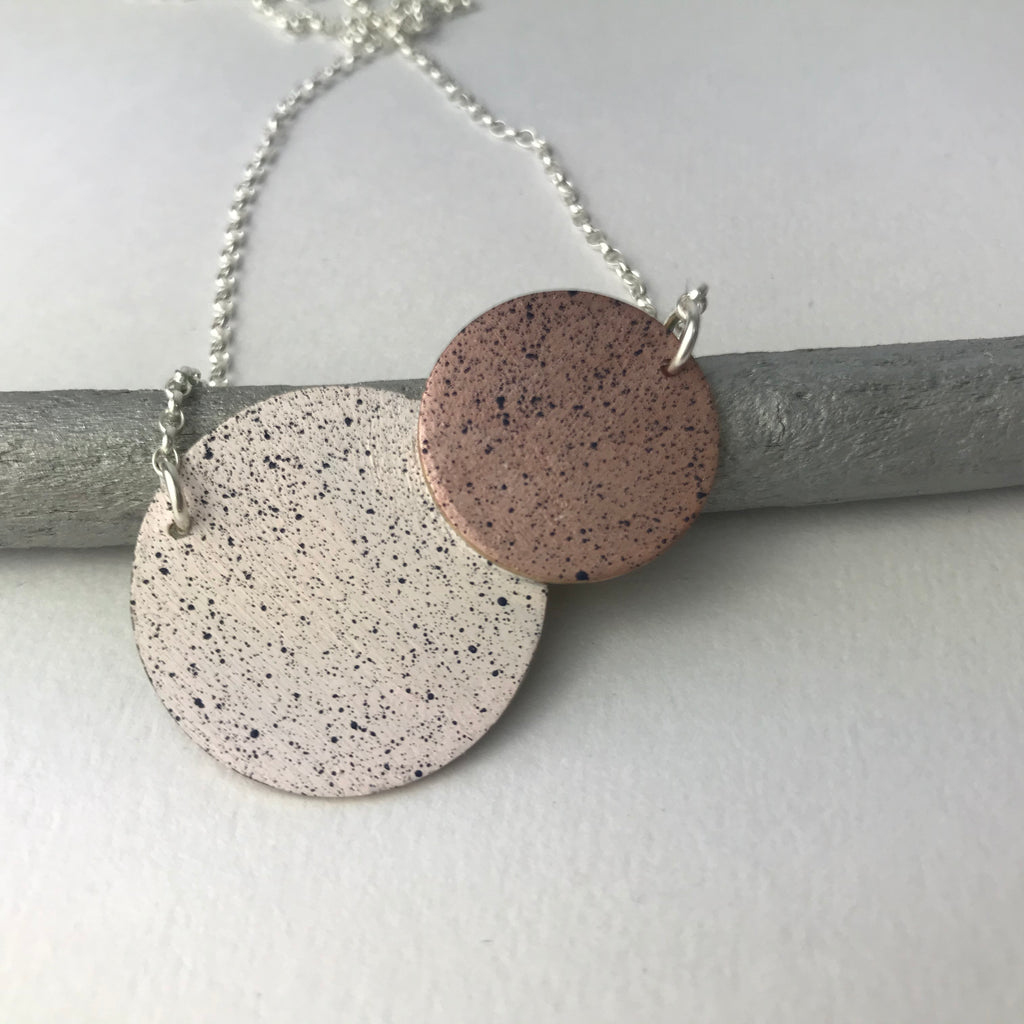 Speckled copper and cream circular pendant necklace on a silver chain.