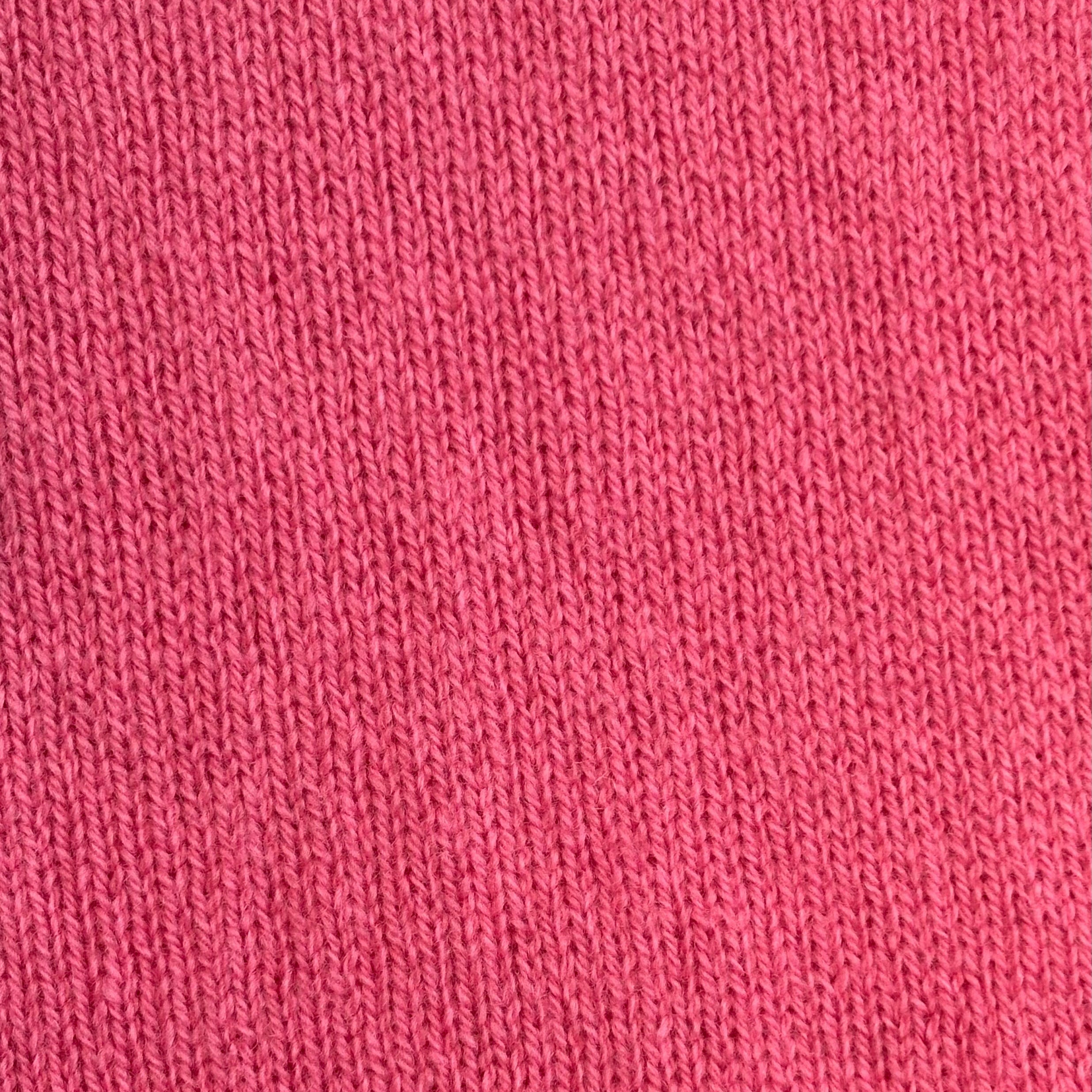 Close-up of pink knitted fabric with a vertical rib texture.