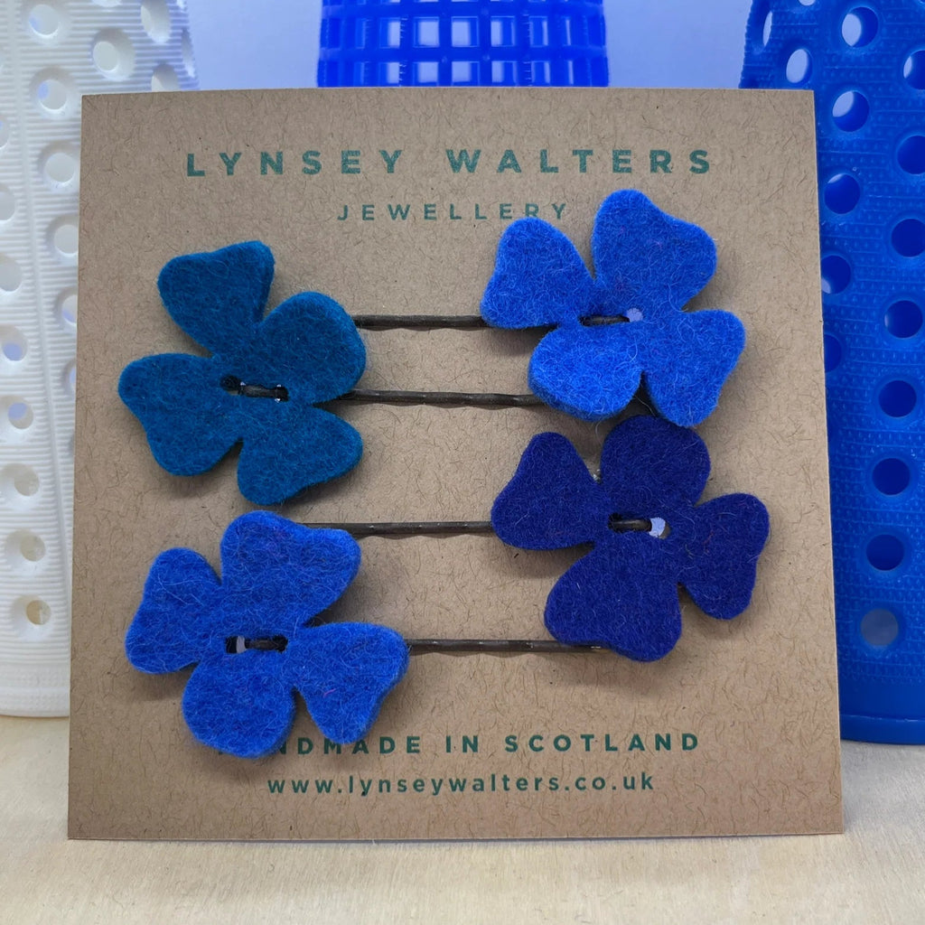 Blue flower-shaped hair pins on a Lynsey Walters branded card with blue background
