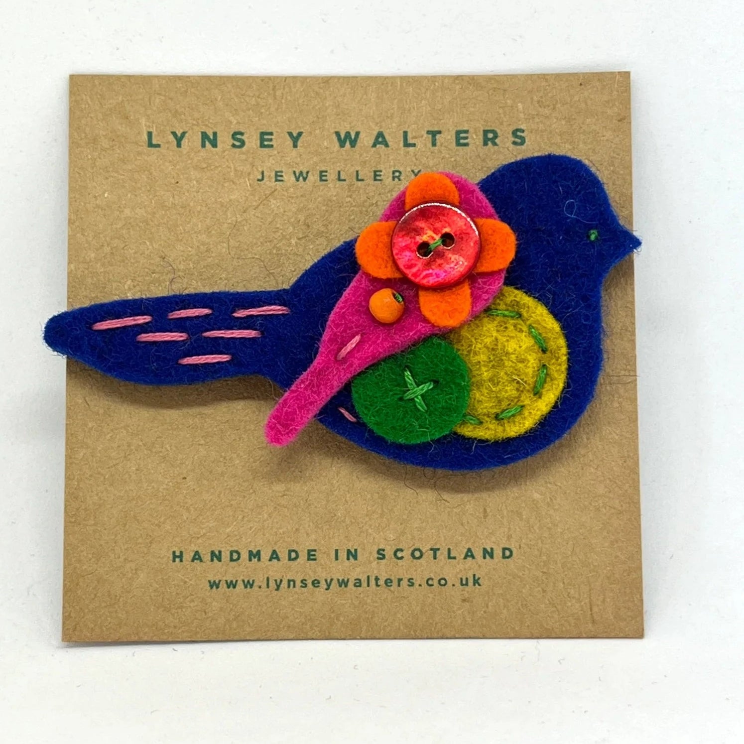 Handmade felt bird brooch with colorful felt flower and button accents.