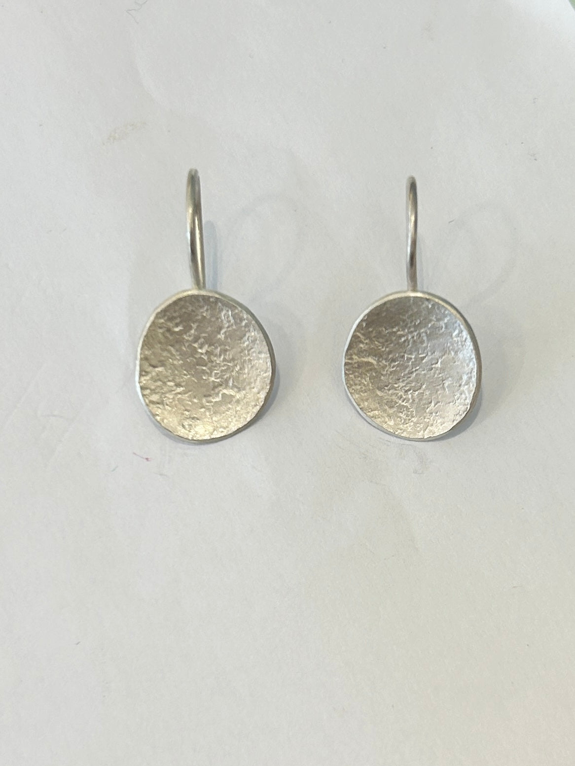 Pair of silver disc earrings with textured surfaces and simple hook closures.