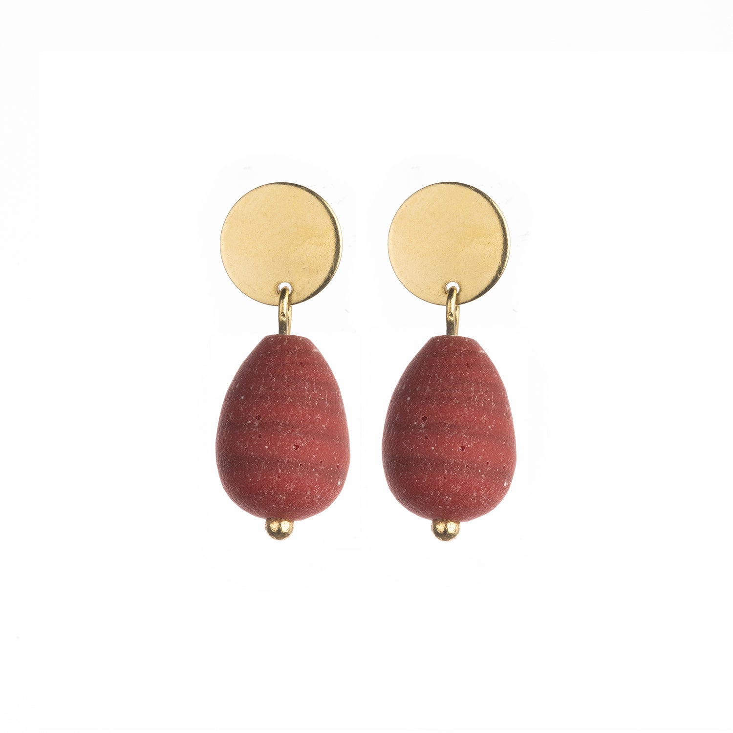 Pair of terracotta-colored teardrop earrings with gold disc and bead accents.