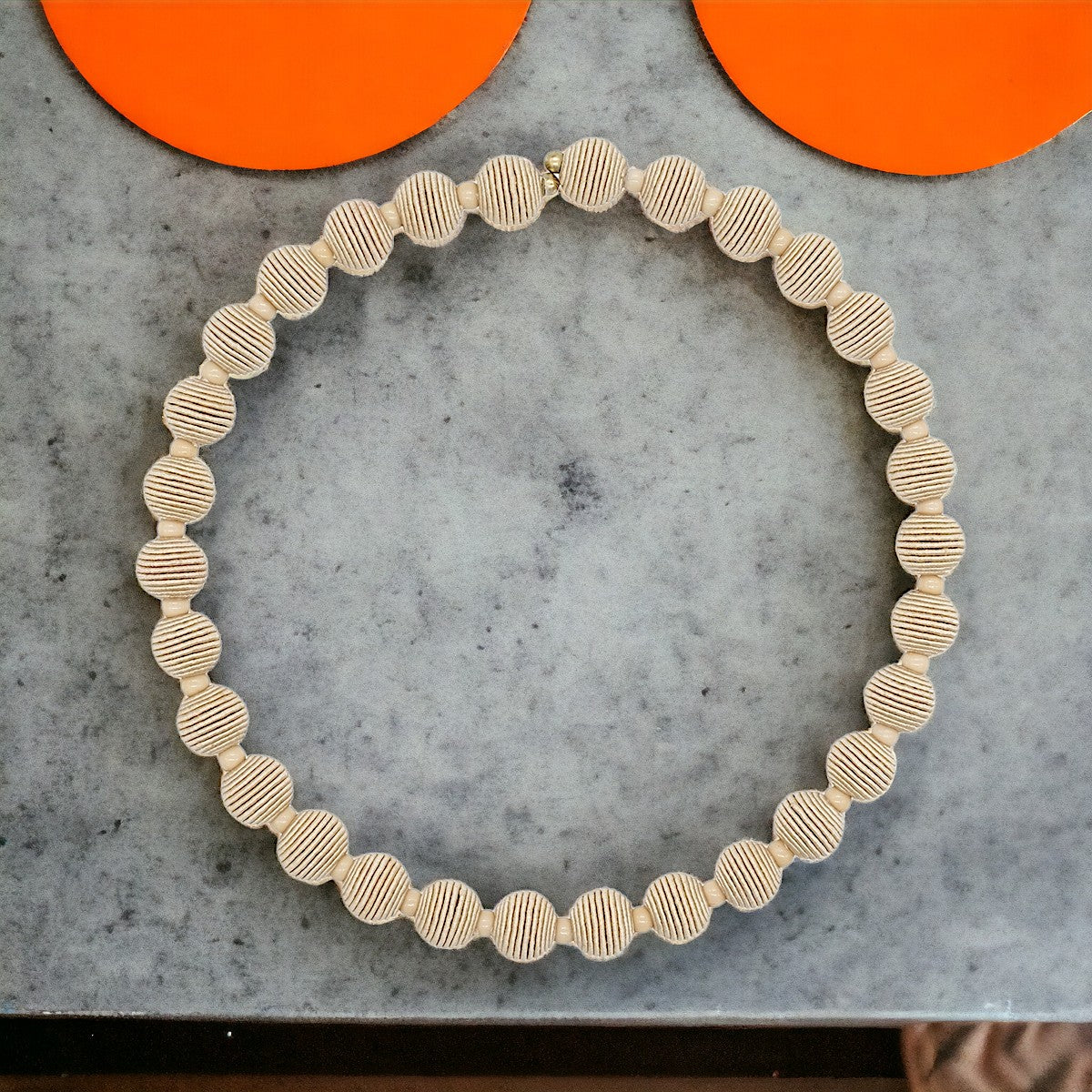 Beige beaded necklace; circular design with textured, ribbed beads.