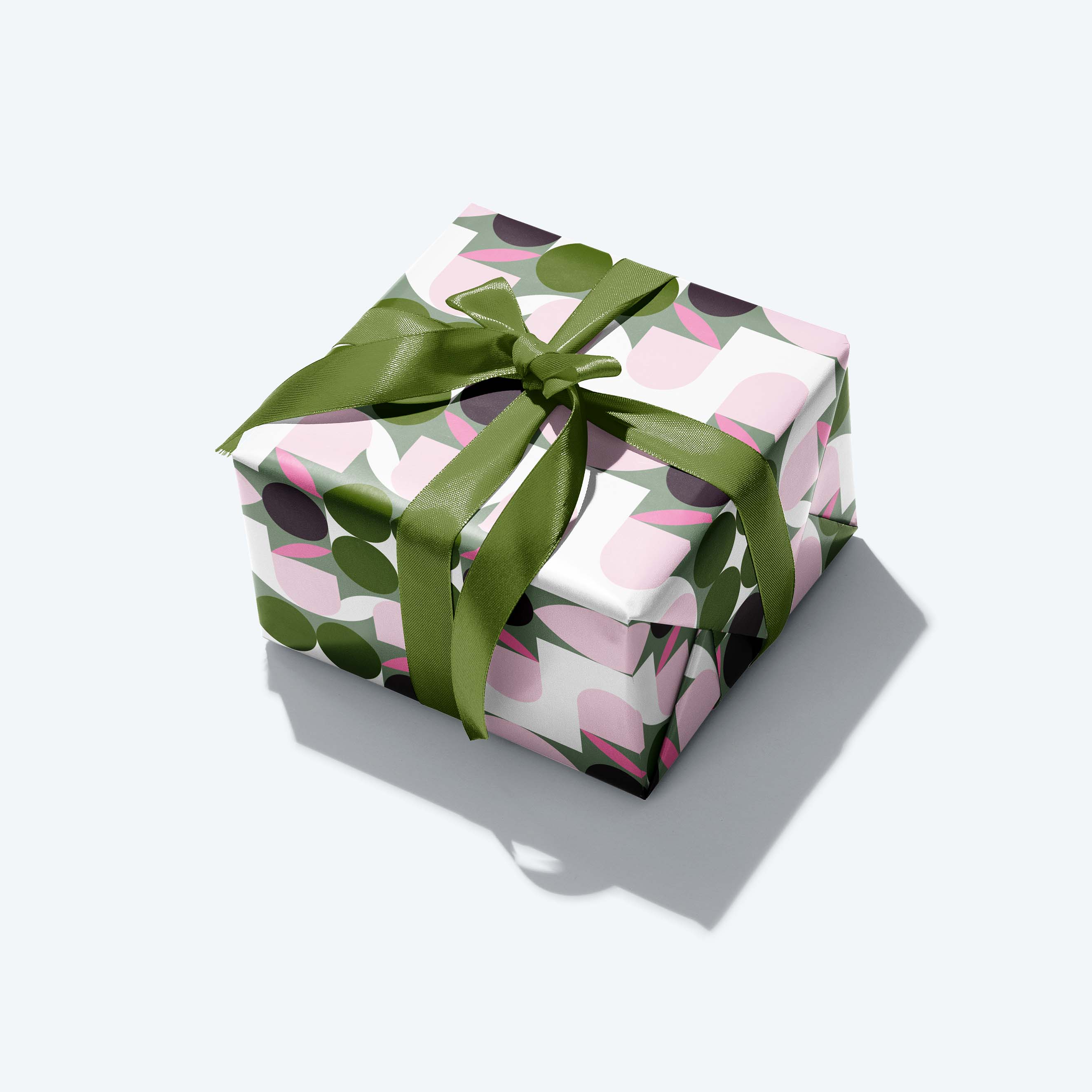 Gift box with floral pattern and green ribbon on a white background