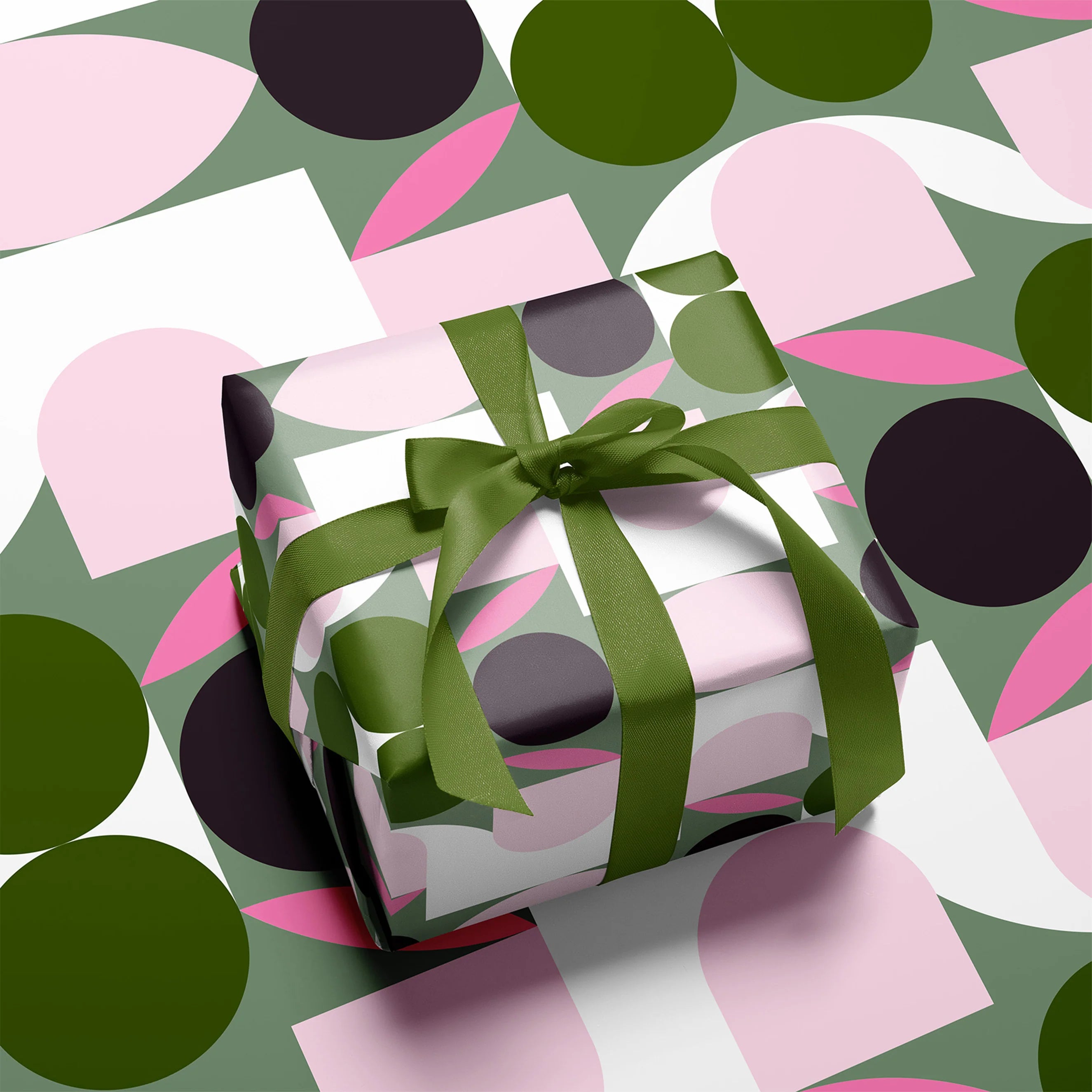 Gift box with green ribbon on a colorful polka dot background