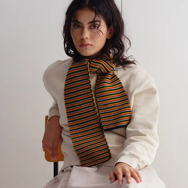 Striped knit scarf in orange, black, and beige.