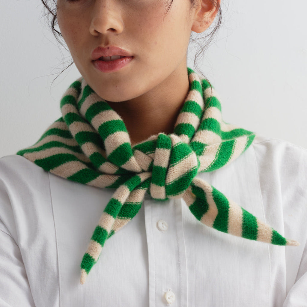 Green and cream striped knitted scarf, tied in a bow at the neck.