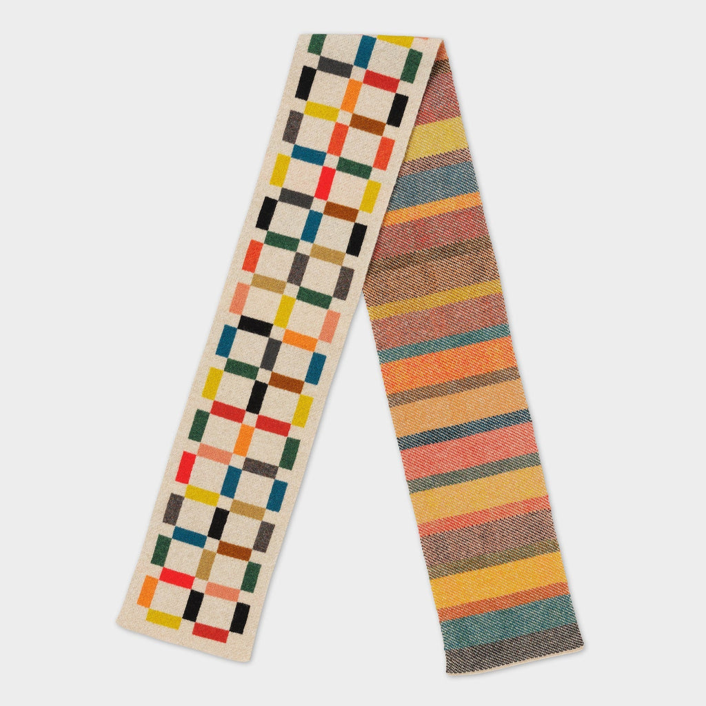 Woven scarf with two distinct patterns: one side features a multicolored grid, the other has horizontal stripes in warm
