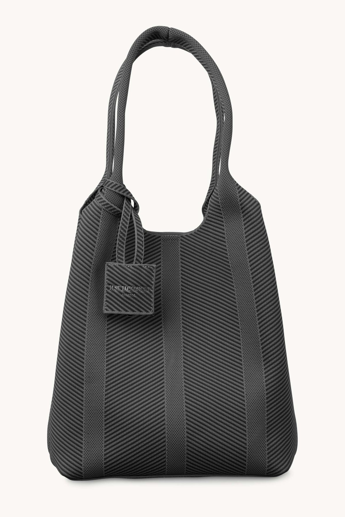 A black textured tote bag with diagonal ribbed patterns and solid black shoulder straps, shown against a plain off-white background.