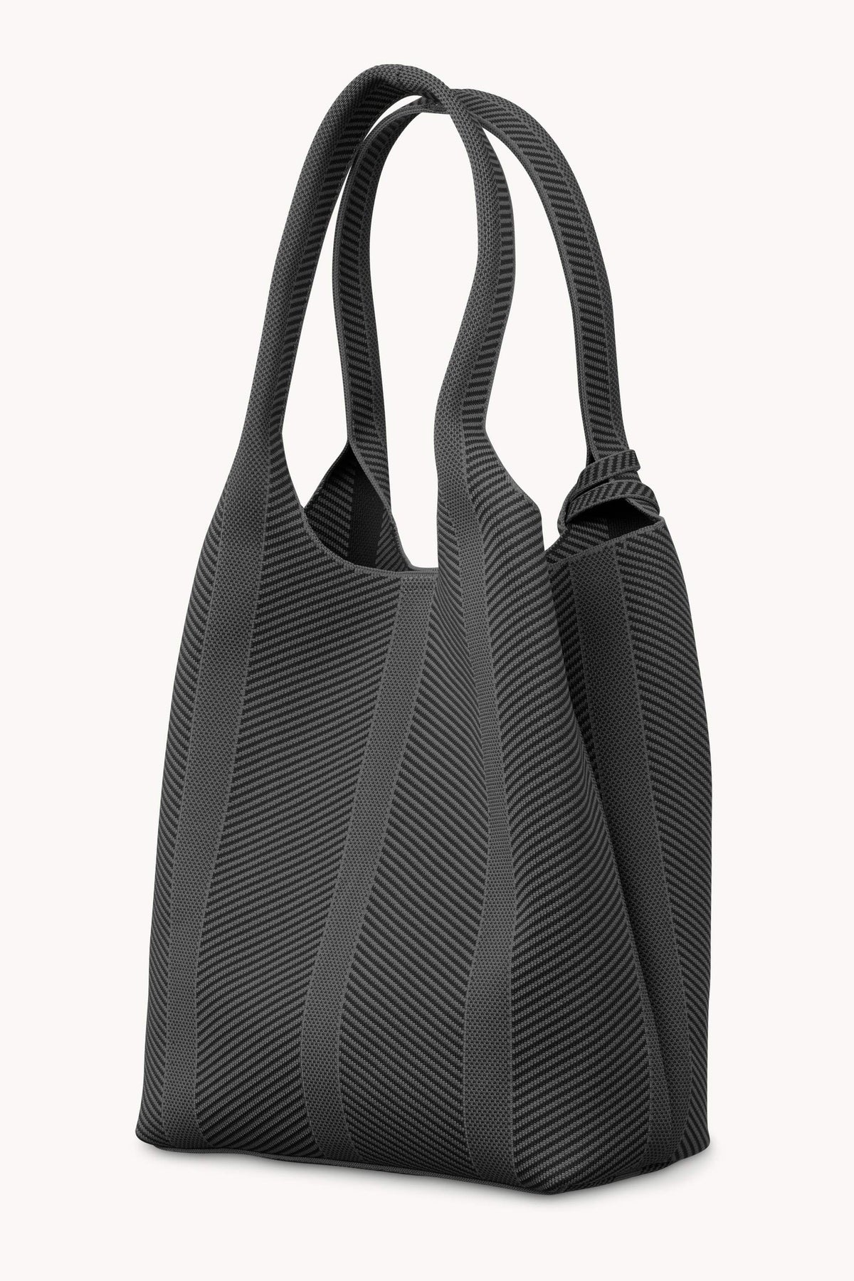 A black textured fabric tote bag with diagonal ribbed stripes and dual shoulder straps, shown on a plain off-white background.