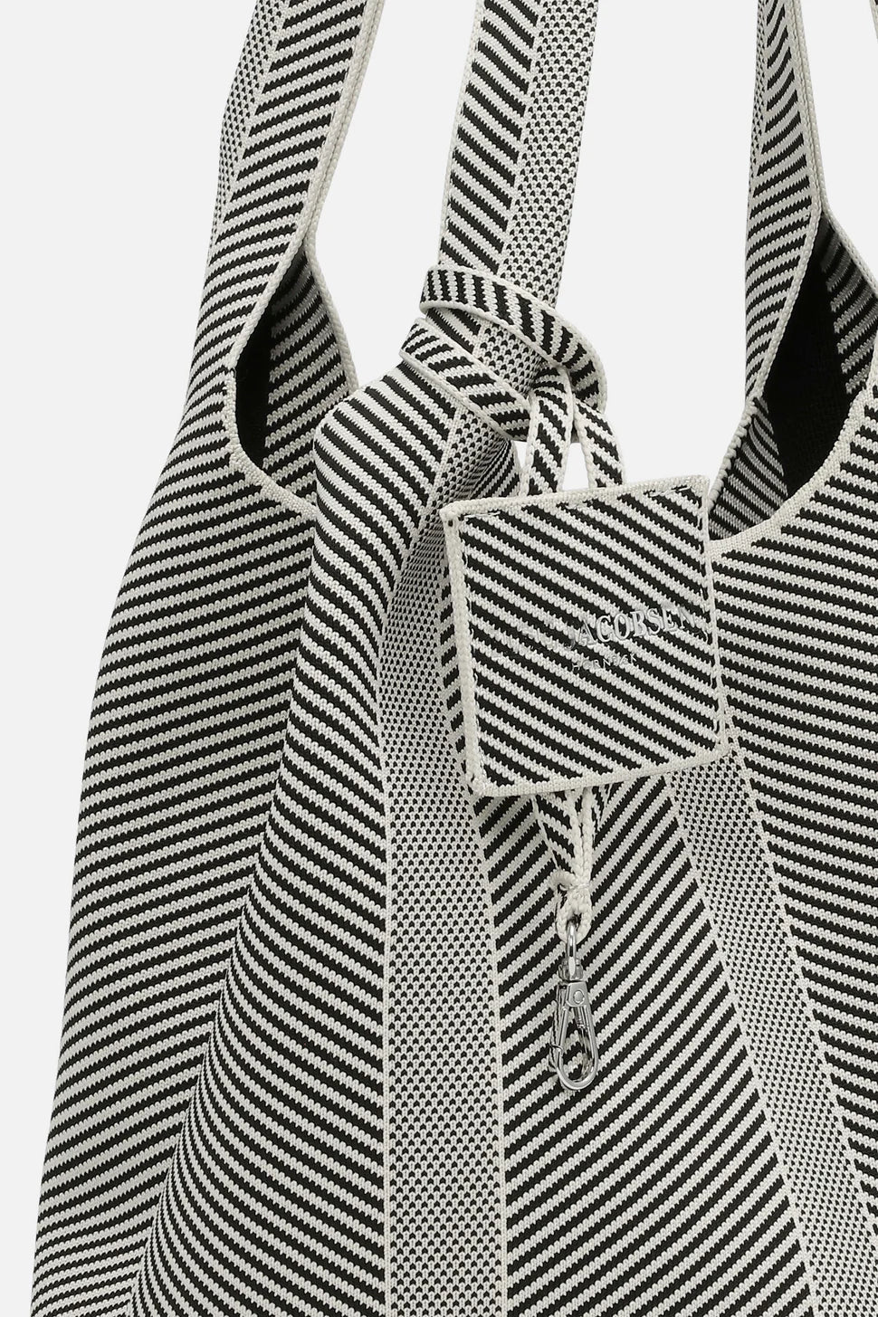 Black and white striped fabric with a patterned texture on a light gray background