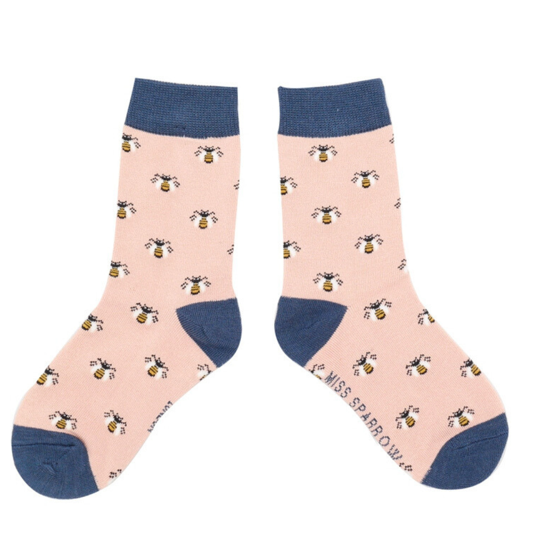 Pair of pink socks with a repeating bee pattern and navy blue cuffs.