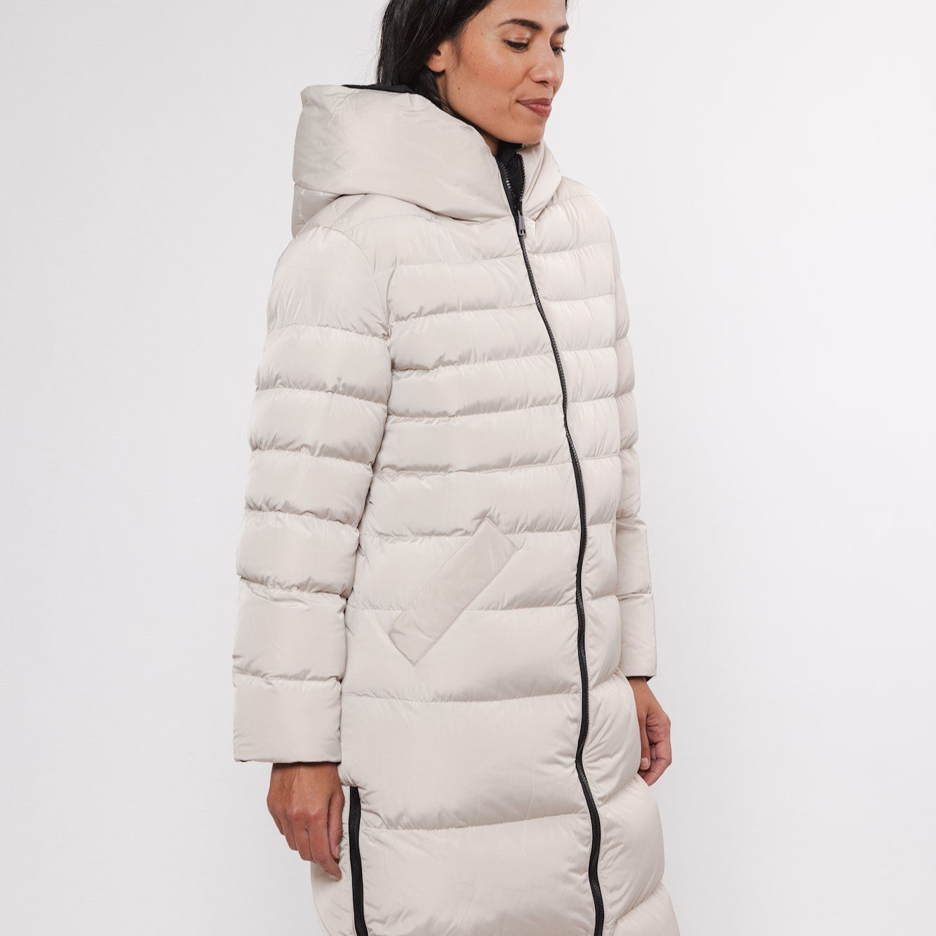 Beige hooded puffer coat with a long length and black zipper.