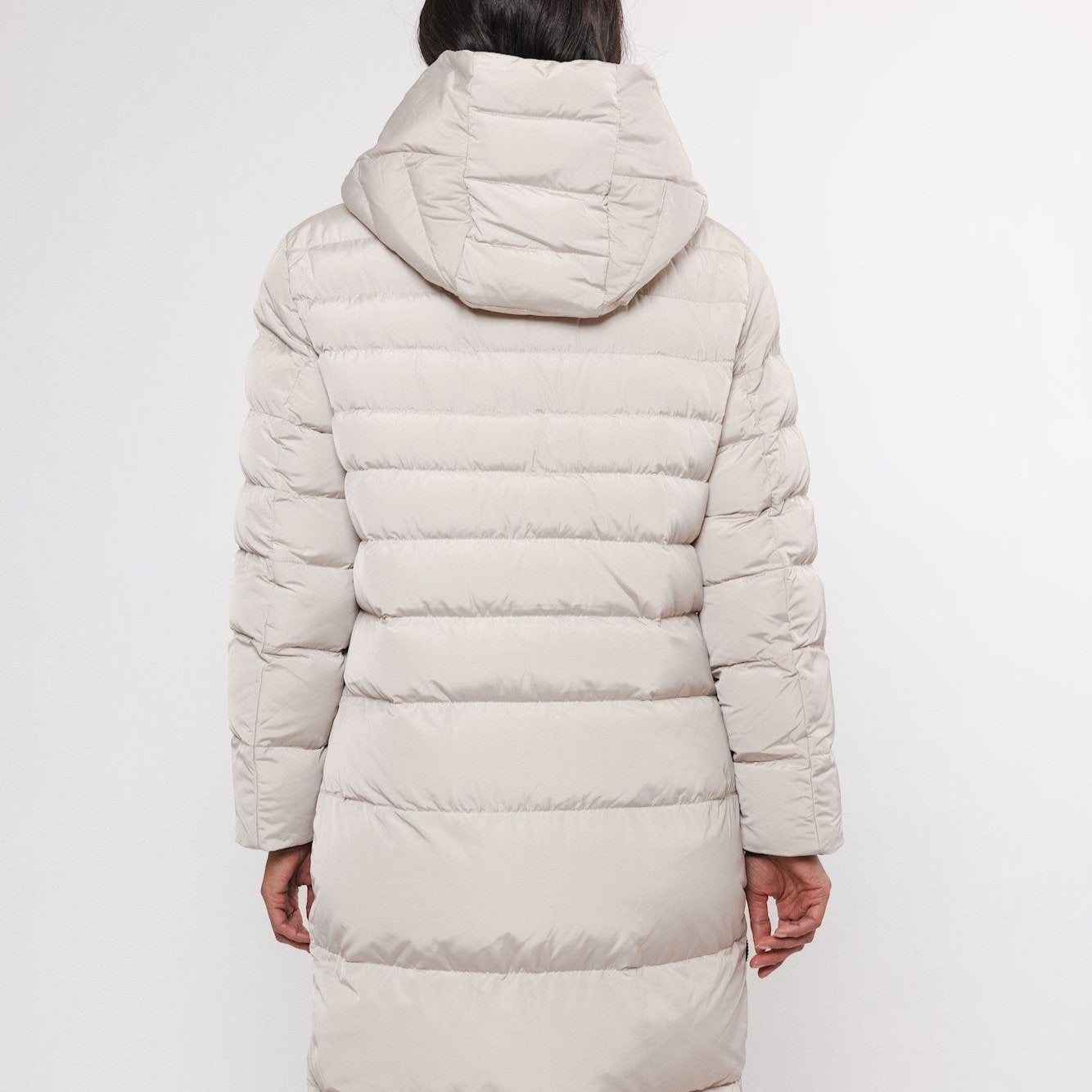 Beige hooded puffer coat with long sleeves and horizontal quilting.