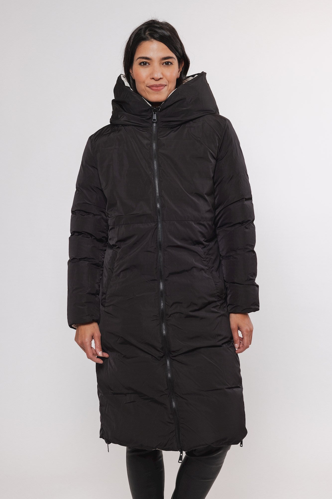 Black quilted long puffer coat with a large, hooded collar and zipper closure.