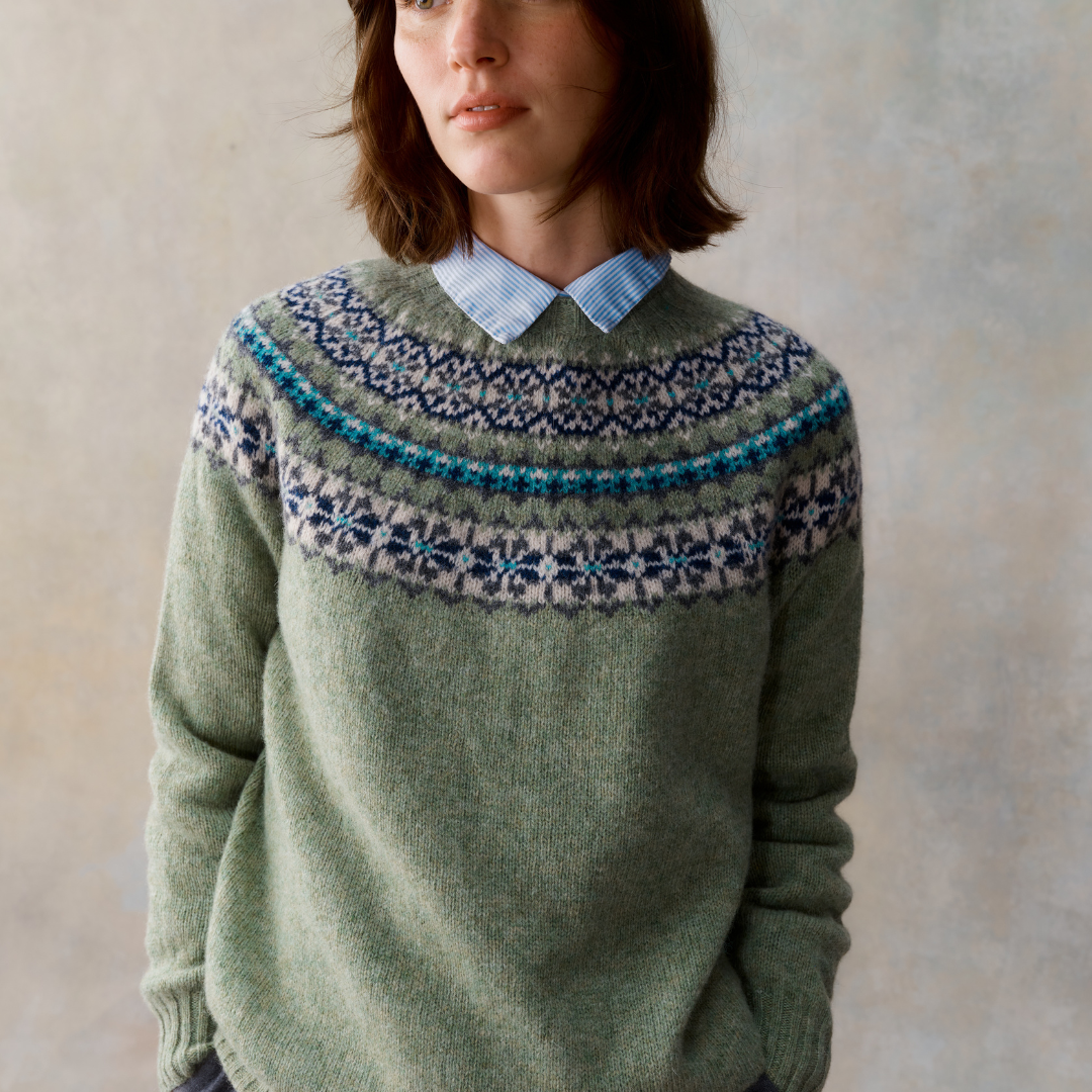 Sage green wool sweater with a Fair Isle yoke featuring teal, navy, and gray snowflake patterns.