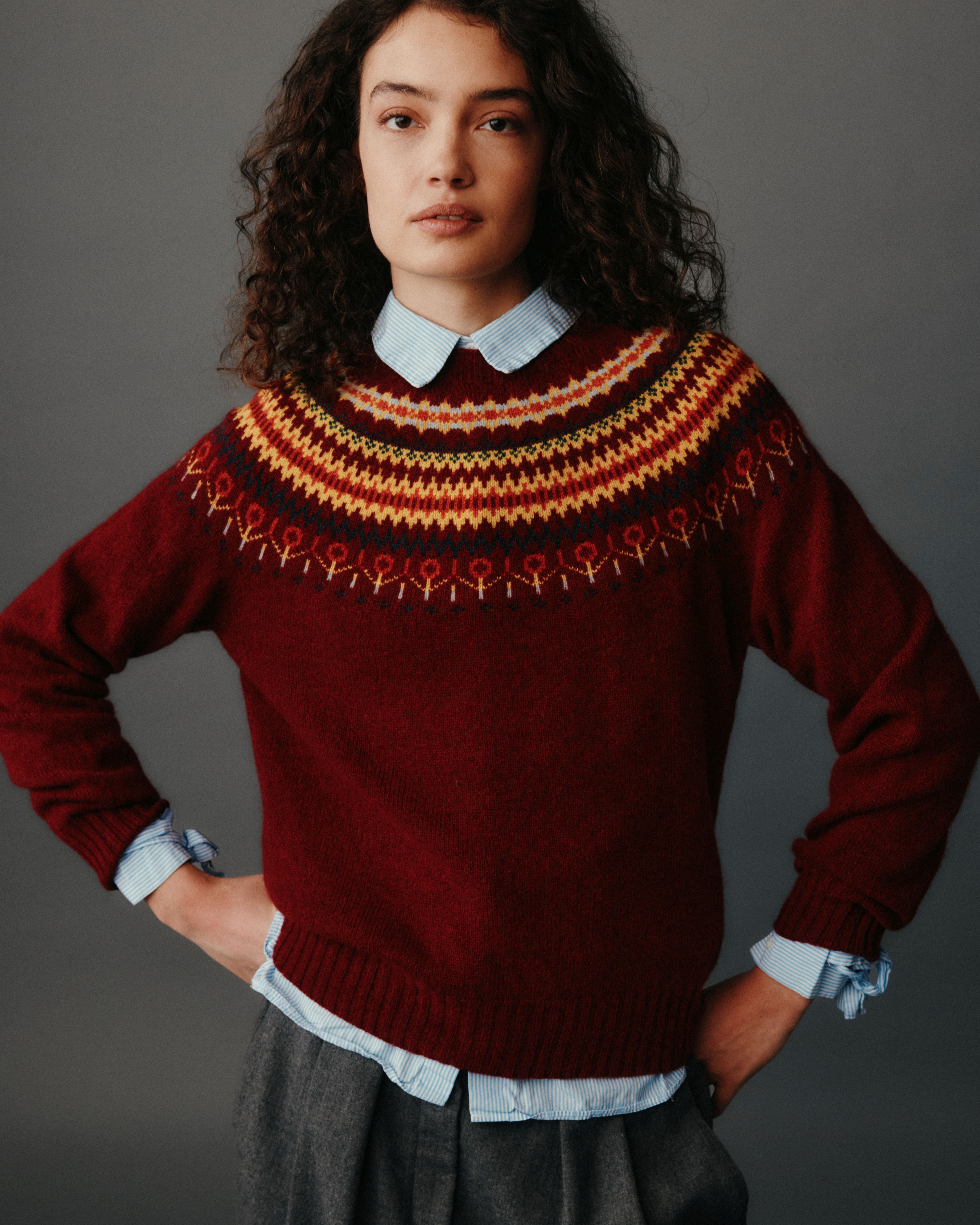Person wearing a patterned sweater with a plain background