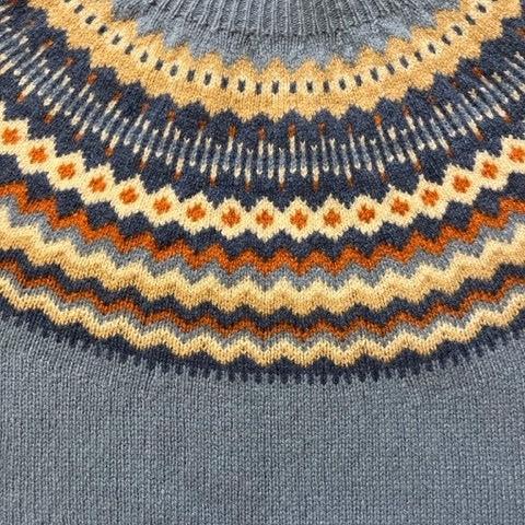 Grey knit sweater with a colorful Fair Isle yoke featuring orange, beige, and dark blue patterns.