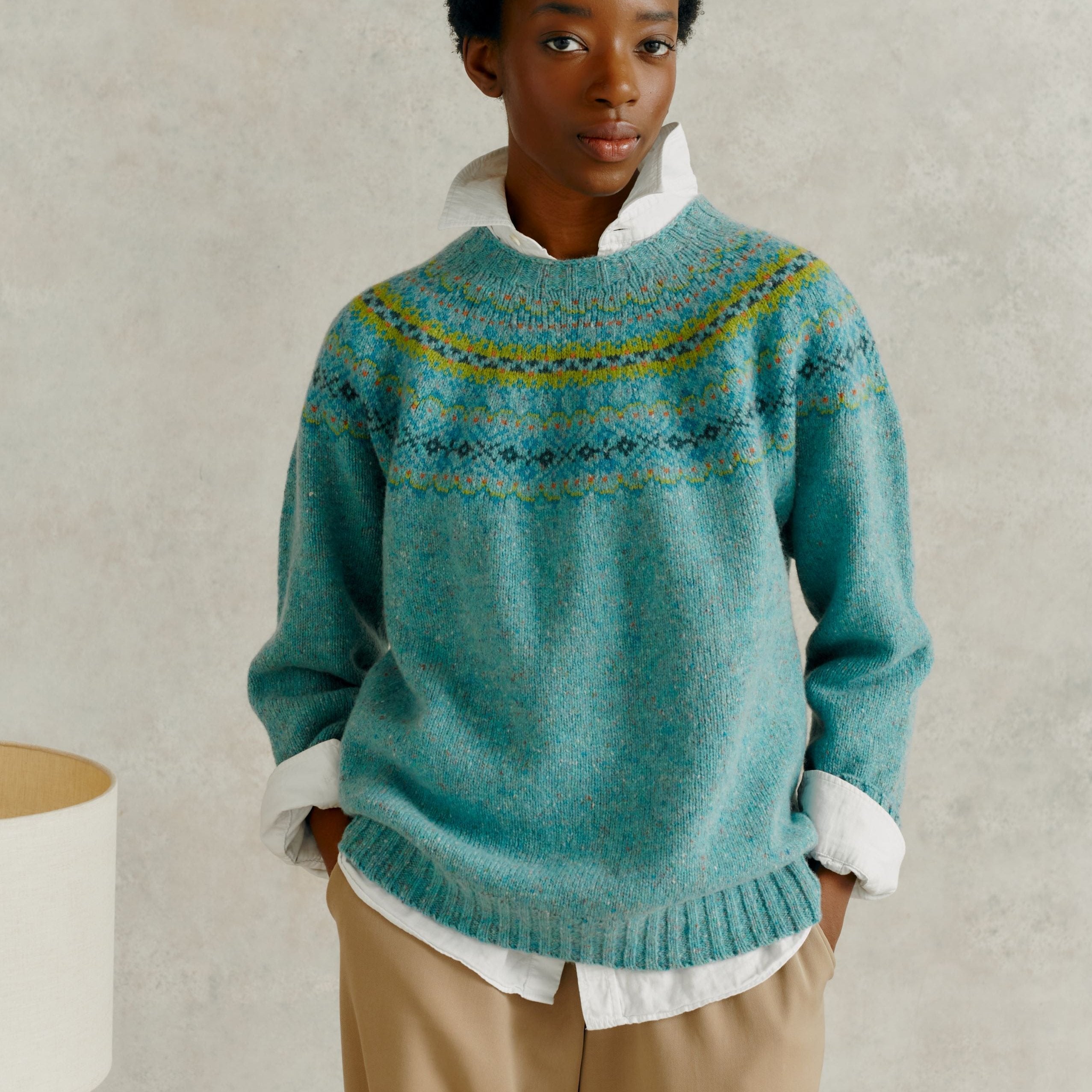 Teal wool sweater with a Fair Isle-style yoke and speckled texture.