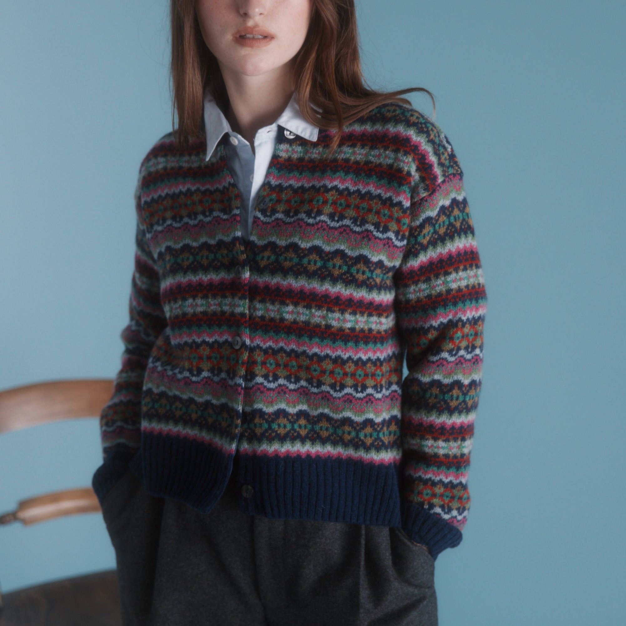 Fair isle patterned cardigan sweater in navy, pink, green, and brown. Button front closure.