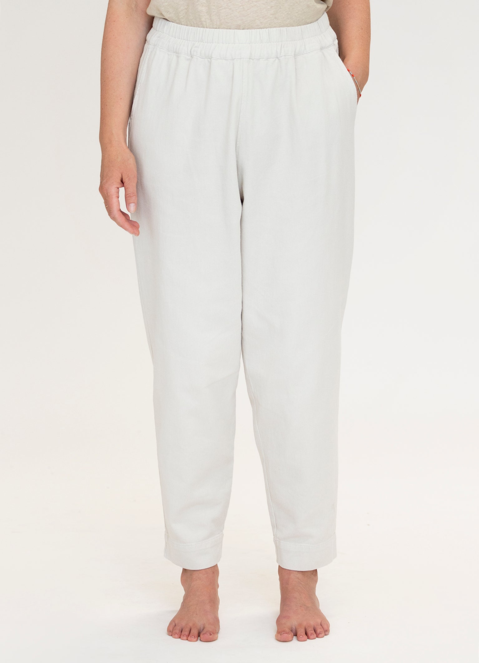 Person wearing white pants on a plain background