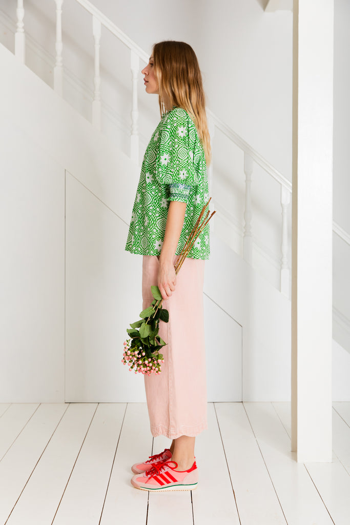 Model in Bonte clothing, featuring a purple and red patterned top, pink wide-leg pants, and pink-red sneakers.