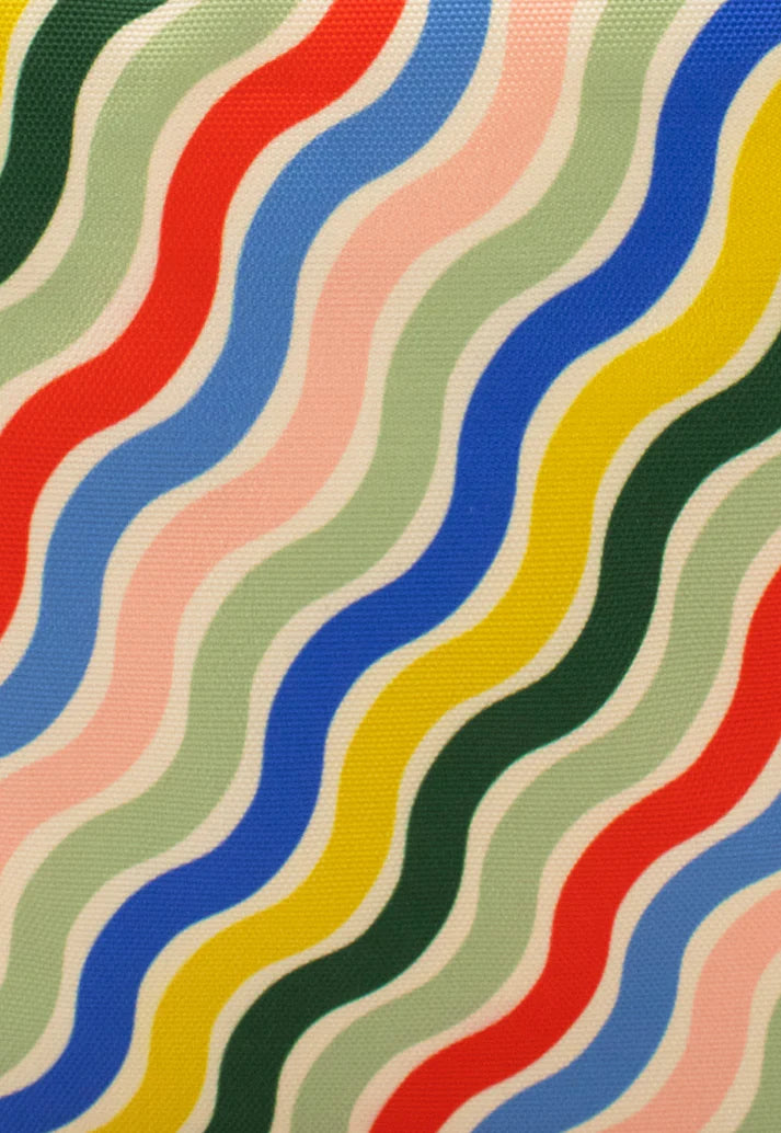 Fabric with multicolored wavy stripes in red, blue, yellow, green, and pink on a cream background.