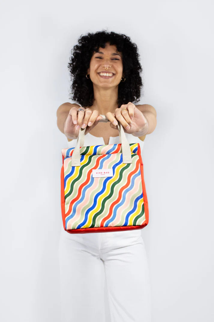 Red insulated lunch bag with multicolored wavy stripes and beige handles.