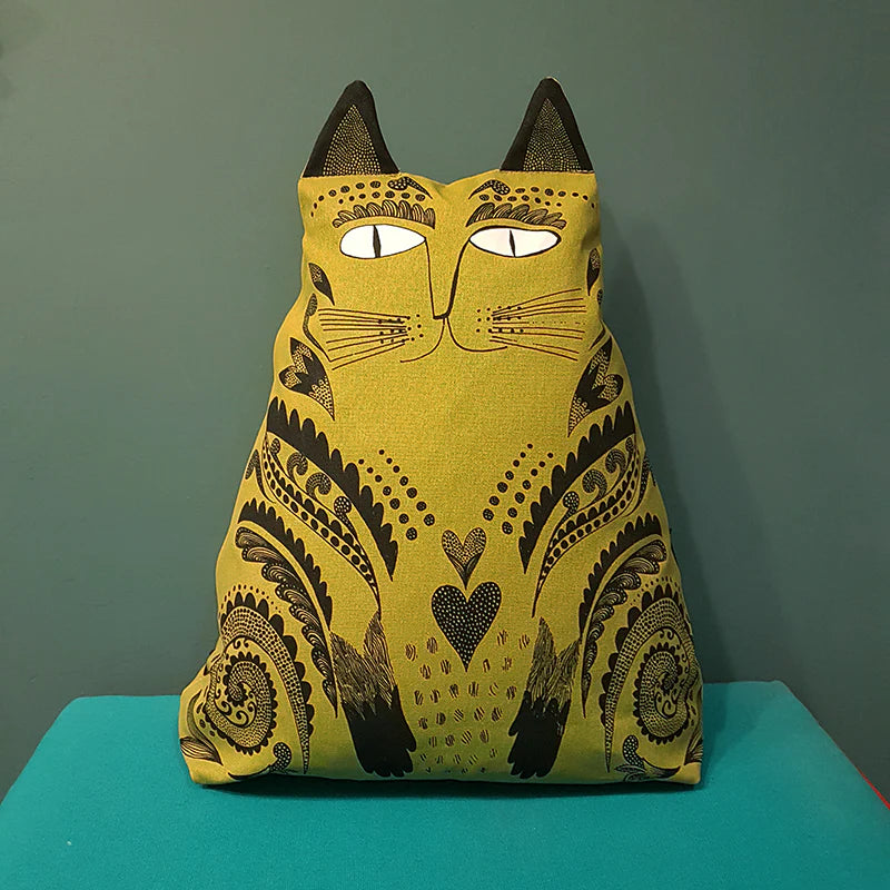 Olive green cat-shaped pillow with black paisley and heart design.