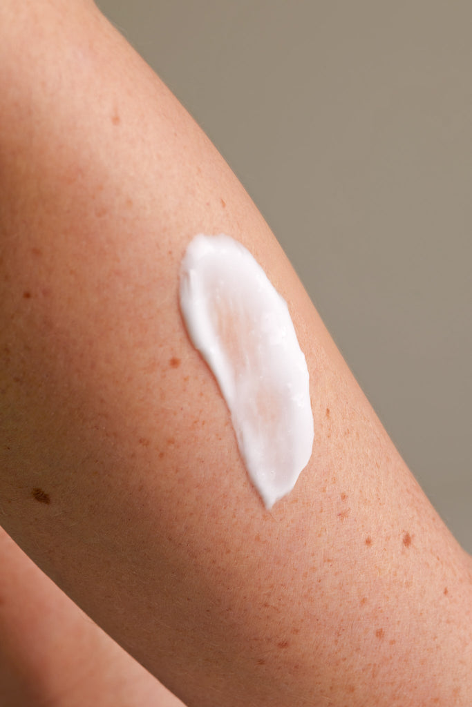 Close-up of skin with white cream, showcasing Chalk UK branding. The arm has a tan tone with freckles.