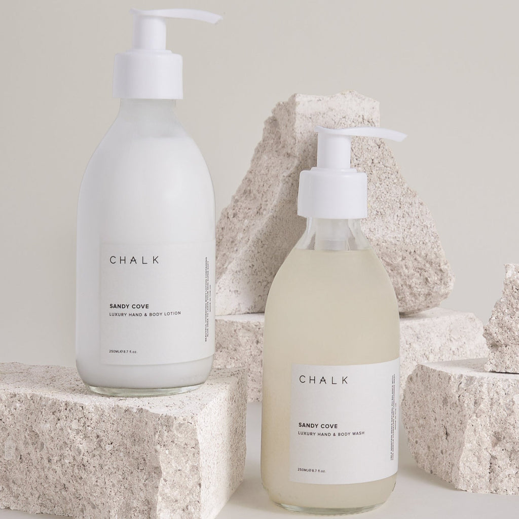 Two Chalk UK products, a white hand and body lotion and a clear hand wash, displayed with textured rocks.
