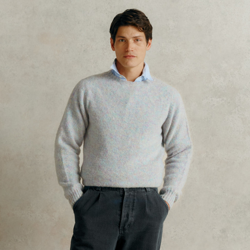 a male model with his hands in the pockets of a pair of grey corduroy trousers, wearing a blue collared shirt and a Harley of Scotland Men's Jumper - Ugie Pearl