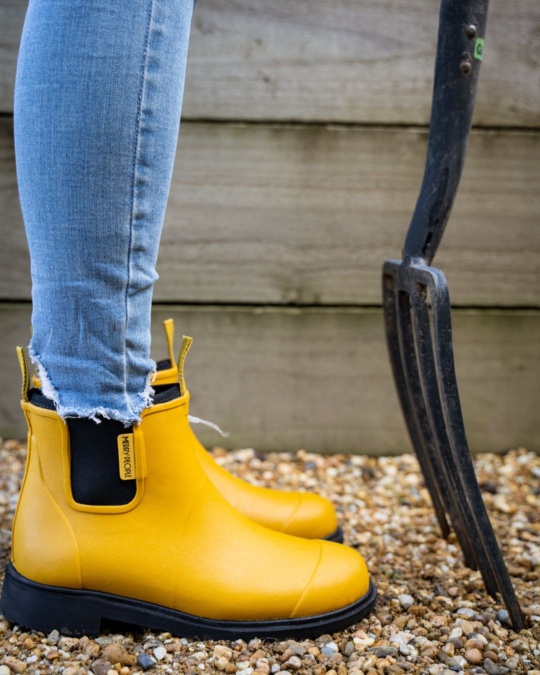 Mustard yellow rubber ankle boots with black soles and a black heel panel.